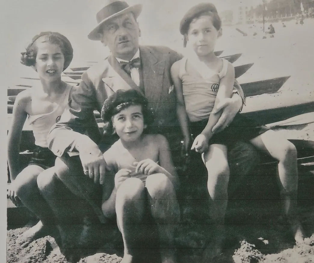 Le père en canotier avec ses trois enfants sur la plage